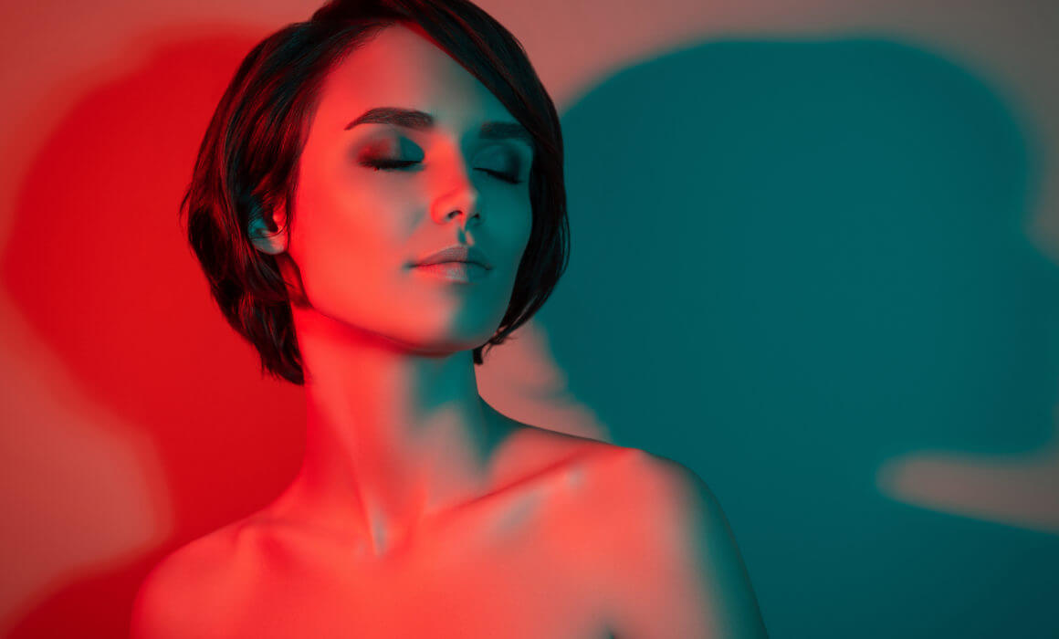 Photo of woman with closed eyes in red light therapy